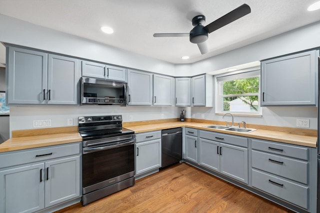 1209 Redbud Dr, Arlington, TX 76012 - kitchen featuring stainless steel appliances, butcher block countertops, a sink, gray cabinetry, and recessed lighting