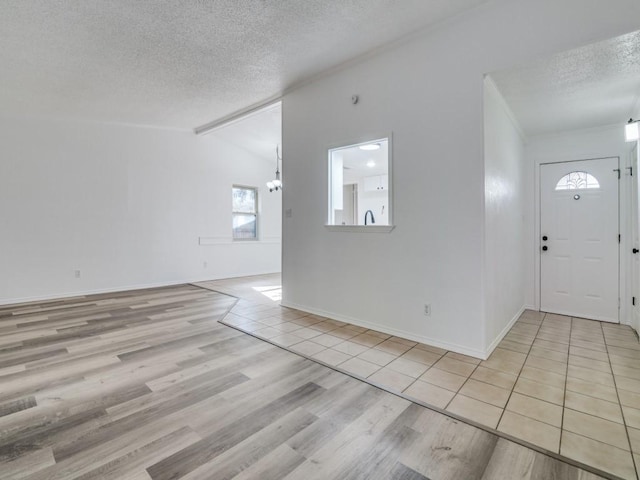 1429 Meadowcrest Dr, Plano, TX 75075 - entryway with a textured ceiling, a chandelier, wood finished floors, vaulted ceiling, and baseboards