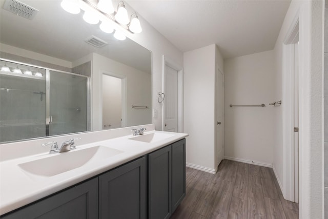 6100 Fall Creek Ln, Fort Worth, TX 76123 - bathroom featuring double vanity, a shower with door, wood finished floors, and baseboards