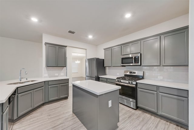 6100 Fall Creek Ln, Fort Worth, TX 76123 - kitchen featuring stainless steel appliances, a sink, decorative backsplash, a center island, and light wood-style floors
