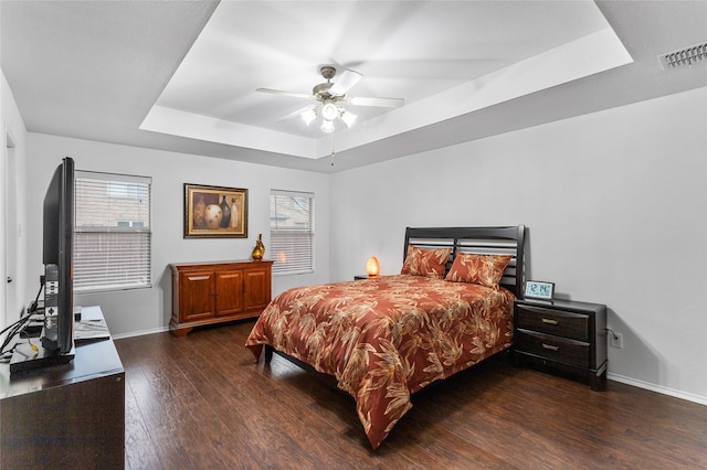 12701 Seagull Way, Frisco, TX 75036 - bedroom with a tray ceiling, dark wood-style floors, baseboards, and a ceiling fan