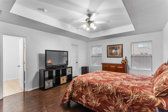 12701 Seagull Way, Frisco, TX 75036 - bedroom with a tray ceiling, wood finished floors, baseboards, and ceiling fan