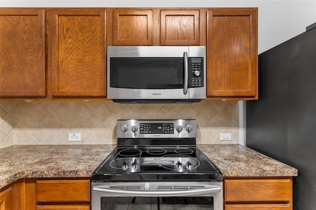 12701 Seagull Way, Frisco, TX 75036 - kitchen with stainless steel appliances, brown cabinetry, and decorative backsplash