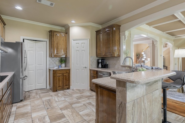 18 Oxford Way, Allen, TX 75002 - kitchen with arched walkways, a sink, decorative columns, a breakfast bar, and light stone countertops