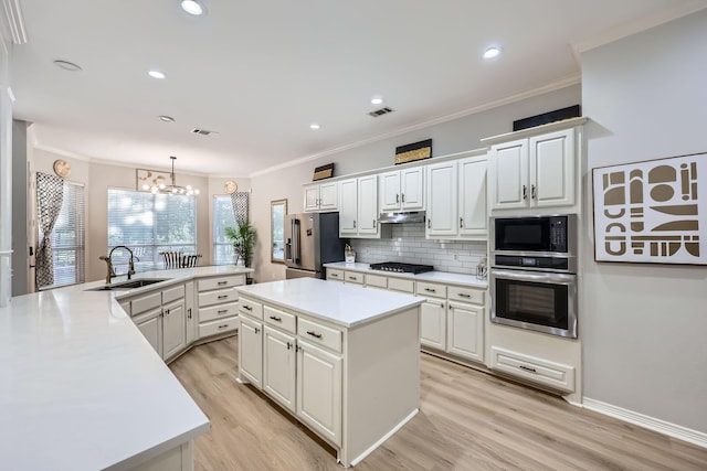 618 Oak Tree Cv, Cedar Hill, TX 75104 - kitchen featuring stainless steel appliances, a sink, under cabinet range hood, a kitchen island, and ornamental molding