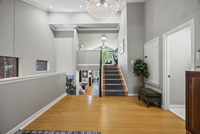 510 Columbia Dr, Rockwall, TX 75032 - foyer featuring a chandelier, wood finished floors, a high ceiling, crown molding, and baseboards
