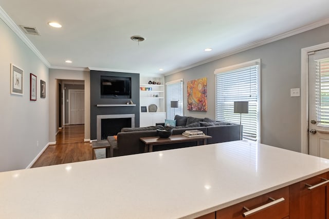 9914 Woodgrove Dr, Dallas, TX 75218 - kitchen with recessed lighting, a fireplace, dark wood-type flooring, crown molding, and light countertops