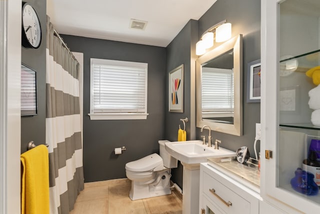 9914 Woodgrove Dr, Dallas, TX 75218 - full bathroom featuring a sink, toilet, baseboards, curtained shower, and tile patterned flooring