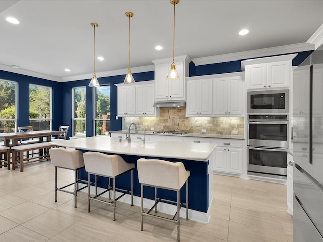 318 Arcadia Way, Rockwall, TX 75087 - kitchen featuring appliances with stainless steel finishes, ornamental molding, decorative backsplash, under cabinet range hood, and a sink