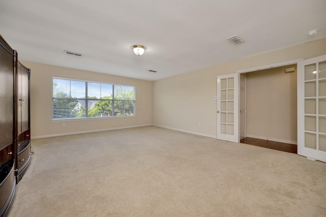 8256 Bridge St, North Richland Hills, TX 76180 - unfurnished bedroom featuring light colored carpet, french doors, and baseboards