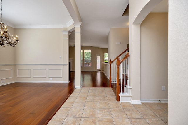 8256 Bridge St, North Richland Hills, TX 76180 - foyer entrance featuring wood finished floors, a chandelier, arched walkways, stairway, and crown molding