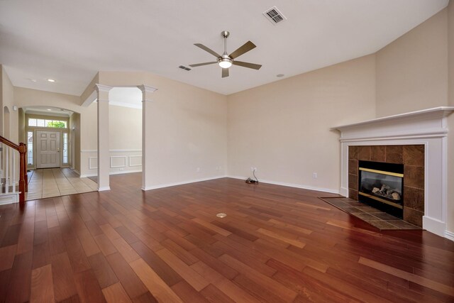 8256 Bridge St, North Richland Hills, TX 76180 - unfurnished living room with wood finished floors, a ceiling fan, arched walkways, a fireplace, and ornate columns