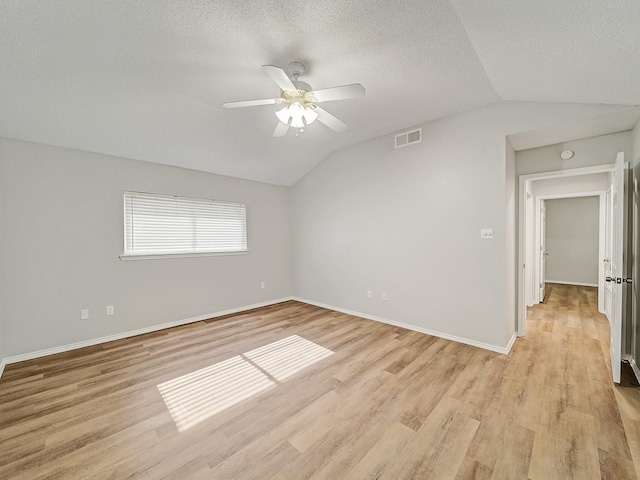 300 Lark Ln, Euless, TX 76039 - empty room featuring lofted ceiling, ceiling fan, light wood-style flooring, baseboards, and a textured ceiling