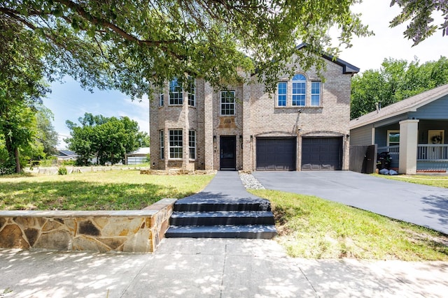 3005 S Jennings Ave, Fort Worth, TX 76110 - view of front of home with brick siding, asphalt driveway, a garage, and a front lawn