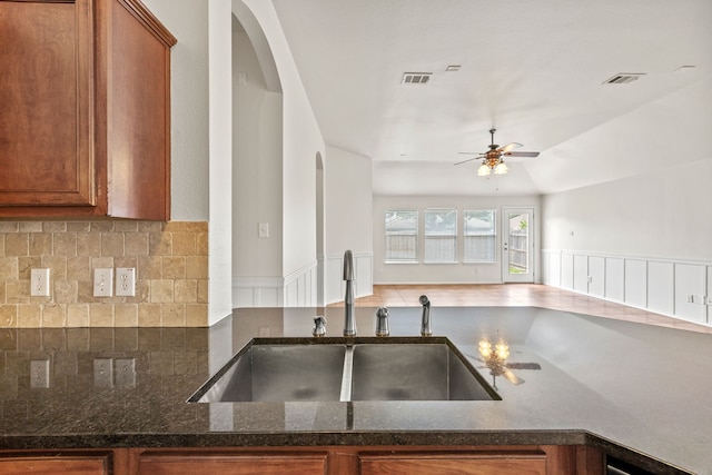 332 Butternut Dr, Fate, TX 75087 - kitchen with a sink, a ceiling fan, open floor plan, brown cabinetry, and tasteful backsplash