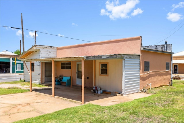 201 S 1st St, Bangs, TX 76823 - back of property featuring a patio, a lawn, and a carport