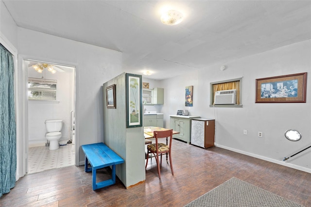 201 S 1st St, Bangs, TX 76823 - kitchen featuring dark wood-style floors, an AC wall unit, baseboards, and fridge