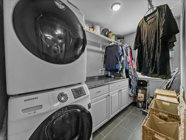 7409 Harbor Dr, Rowlett, TX 75088 - laundry room with stacked washer / drying machine, dark tile patterned floors, and cabinet space