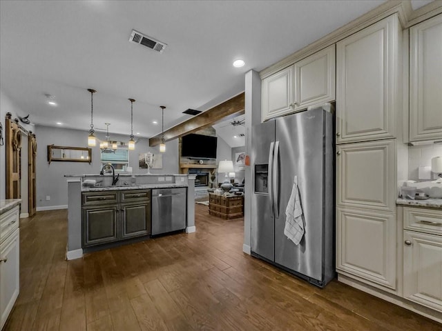 7409 Harbor Dr, Rowlett, TX 75088 - kitchen featuring stainless steel appliances, cream cabinetry, a sink, dark wood-style floors, and open floor plan