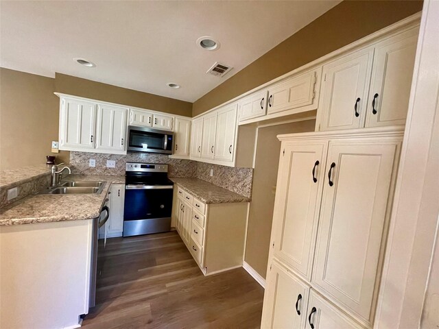 2955 Allister St, Dallas, TX 75229 - kitchen featuring stainless steel appliances, a sink, tasteful backsplash, dark wood finished floors, and white cabinetry