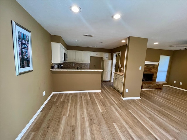 2955 Allister St, Dallas, TX 75229 - kitchen featuring open floor plan, a peninsula, stainless steel microwave, light wood-style flooring, and recessed lighting