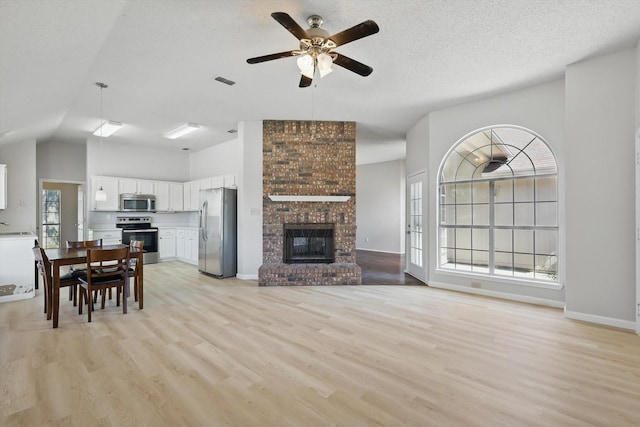 7100 Fox Dr, The Colony, TX 75056 - living room featuring light wood finished floors, healthy amount of natural light, a ceiling fan, and lofted ceiling