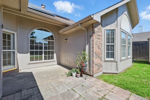 7100 Fox Dr, The Colony, TX 75056 - property entrance with a patio area, roof mounted solar panels, and brick siding