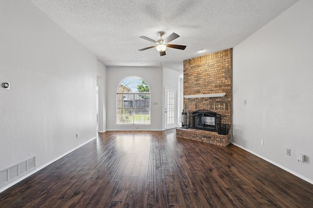 7100 Fox Dr, The Colony, TX 75056 - unfurnished living room featuring a ceiling fan, a textured ceiling, dark wood-style flooring, a brick fireplace, and baseboards