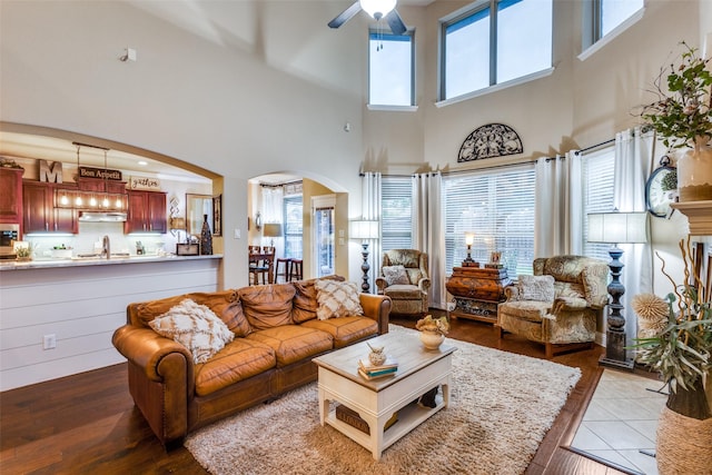 2801 Adams Dr, Melissa, TX 75454 - living room featuring arched walkways, a ceiling fan, hardwood / wood-style floors, and a towering ceiling