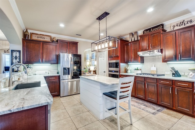 2801 Adams Dr, Melissa, TX 75454 - kitchen with appliances with stainless steel finishes, arched walkways, a sink, under cabinet range hood, and reddish brown cabinets