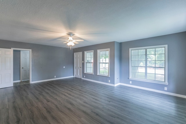 901 E Walnut St, Hillsboro, TX 76645 - spare room with baseboards, a ceiling fan, plenty of natural light, dark wood-type flooring, and a textured ceiling