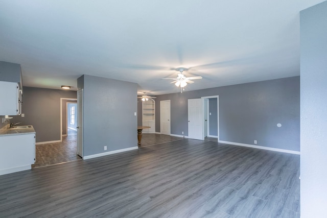 901 E Walnut St, Hillsboro, TX 76645 - unfurnished living room with a ceiling fan, a sink, dark wood finished floors, and baseboards