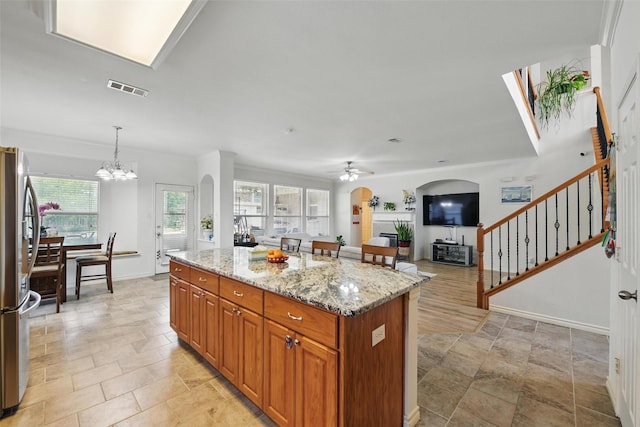 9829 Crawford Farms Dr, Fort Worth, TX 76244 - kitchen with freestanding refrigerator, ceiling fan, a center island, light stone countertops, and a chandelier