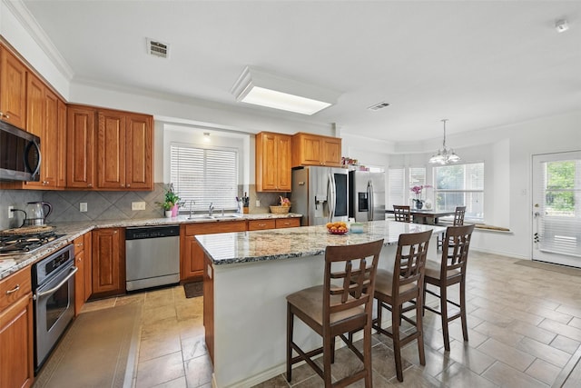 9829 Crawford Farms Dr, Fort Worth, TX 76244 - kitchen with stainless steel appliances, a sink, backsplash, a kitchen island, and light stone countertops