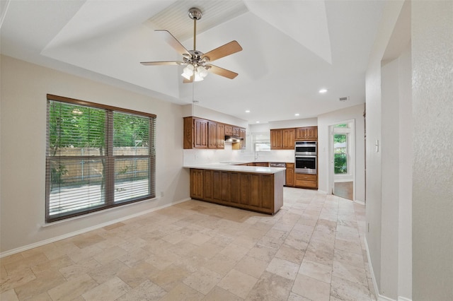 5518 Oak Branch Dr, Arlington, TX 76016 - kitchen featuring baseboards, stainless steel double oven, stone tile floors, brown cabinets, and a peninsula
