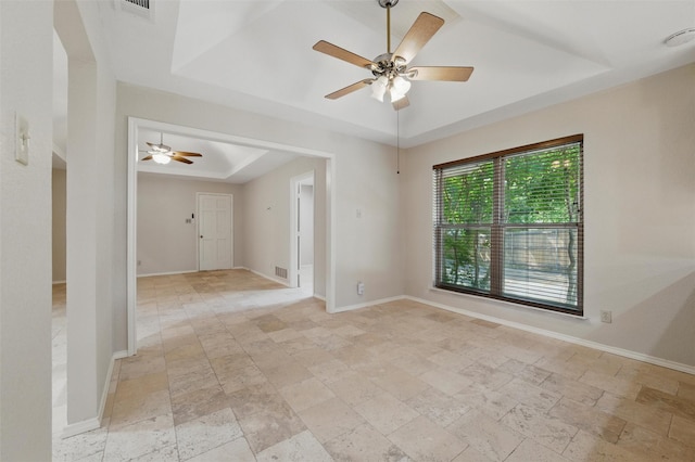 5518 Oak Branch Dr, Arlington, TX 76016 - unfurnished room with a tray ceiling, ceiling fan, light stone finish floors, and baseboards