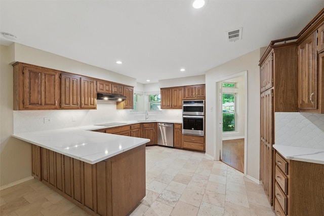 5518 Oak Branch Dr, Arlington, TX 76016 - kitchen featuring appliances with stainless steel finishes, tasteful backsplash, a peninsula, a sink, and recessed lighting