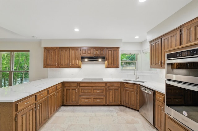 5518 Oak Branch Dr, Arlington, TX 76016 - kitchen featuring stainless steel appliances, brown cabinets, under cabinet range hood, a sink, and a peninsula