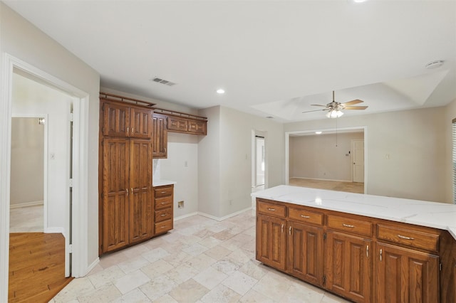 5518 Oak Branch Dr, Arlington, TX 76016 - kitchen with ceiling fan, baseboards, light stone countertops, recessed lighting, and brown cabinetry