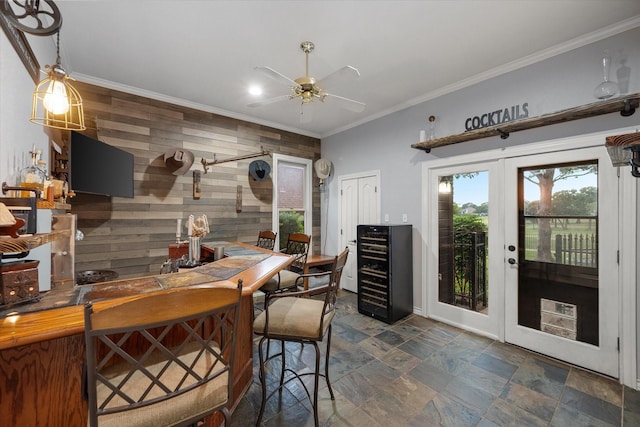 719 Morningside Dr, Mansfield, TX 76063 - dining space with wine cooler, wooden walls, ornamental molding, stone finish flooring, and ceiling fan