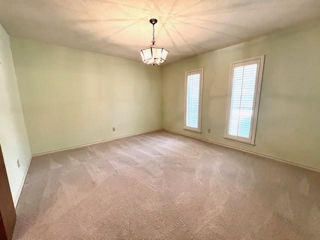2621 Picadilly Ln, Denton, TX 76209 - empty room featuring light colored carpet, a chandelier, and baseboards
