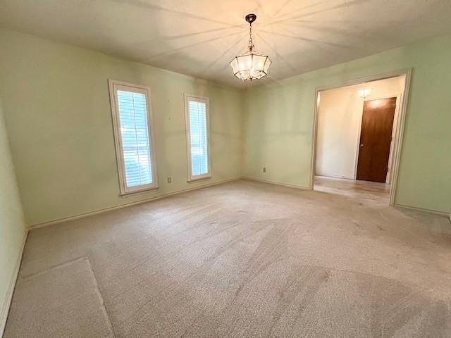 2621 Picadilly Ln, Denton, TX 76209 - unfurnished room with a chandelier, baseboards, and light carpet