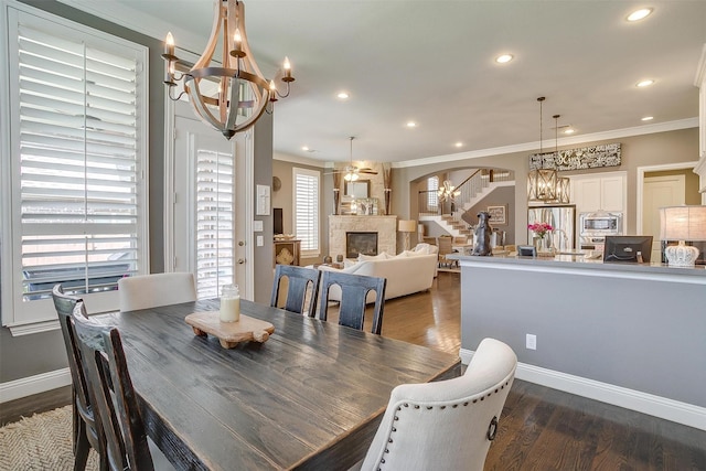 6309 Willow Ridge Trl, Flower Mound, TX 76226 - dining space with a chandelier, a fireplace, plenty of natural light, ornamental molding, and recessed lighting