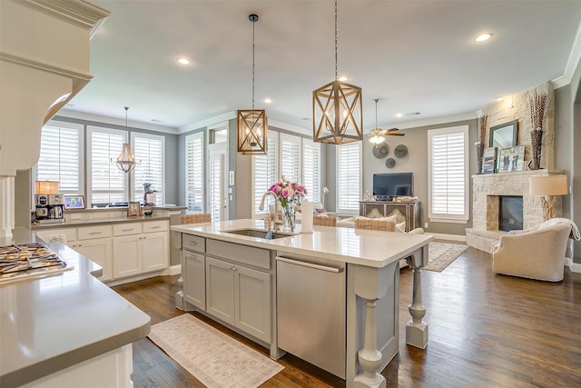 6309 Willow Ridge Trl, Flower Mound, TX 76226 - kitchen with a sink, appliances with stainless steel finishes, a stone fireplace, light countertops, and a center island with sink