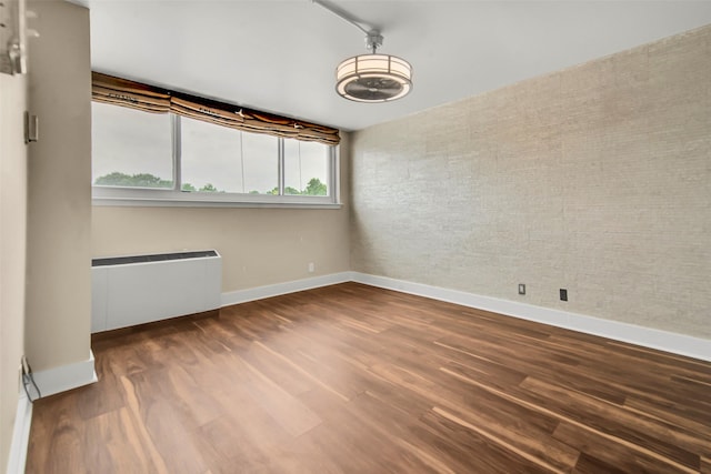 3883 Turtle Creek Blvd Unit 204, Dallas, TX 75219 - spare room with baseboards, radiator heating unit, and wood finished floors