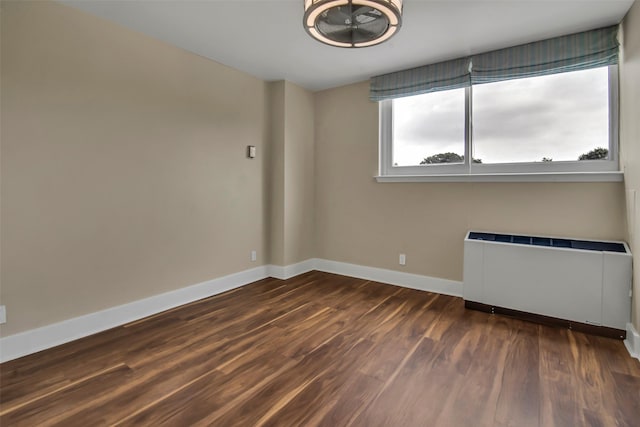 3883 Turtle Creek Blvd Unit 204, Dallas, TX 75219 - empty room with radiator heating unit, baseboards, and dark wood-style flooring