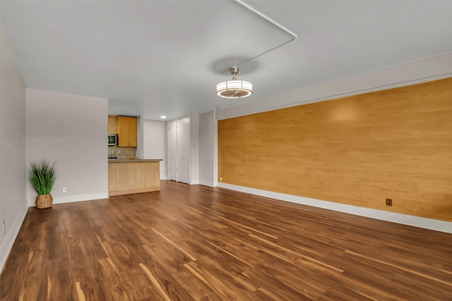 3883 Turtle Creek Blvd Unit 204, Dallas, TX 75219 - unfurnished living room with baseboards and dark wood-style flooring
