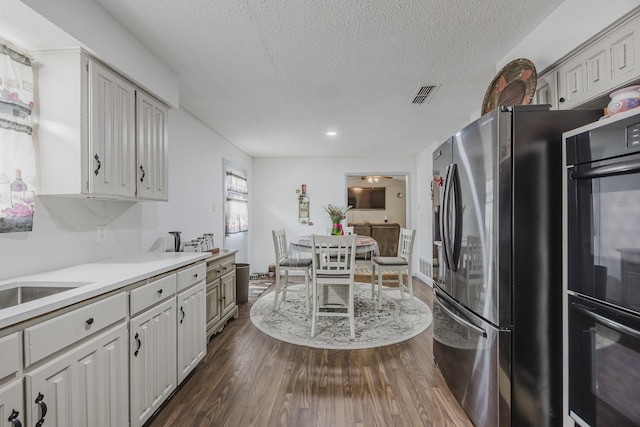 1808 Tameria Dr, Irving, TX 75060 - kitchen with stainless steel refrigerator with ice dispenser, dark wood finished floors, a textured ceiling, light countertops, and recessed lighting