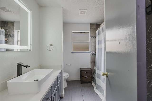 1808 Tameria Dr, Irving, TX 75060 - full bathroom featuring a textured ceiling, toilet, vanity, a shower with shower curtain, and baseboards
