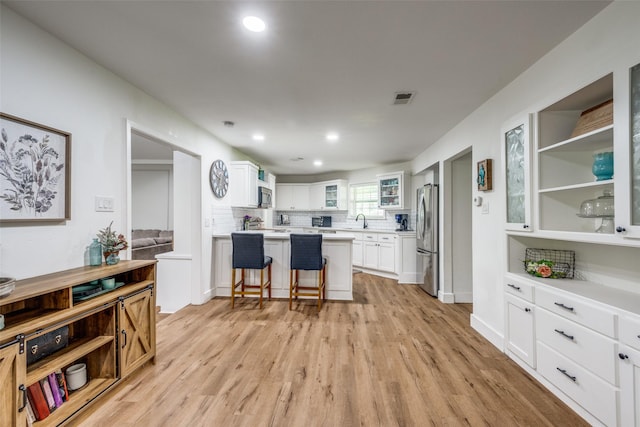 2208 Turtle Creek Dr, Sherman, TX 75092 - kitchen with stainless steel appliances, a sink, light wood finished floors, a kitchen breakfast bar, and recessed lighting